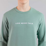 LOVE NEVER FAILS SWEATSHIRT SAGE